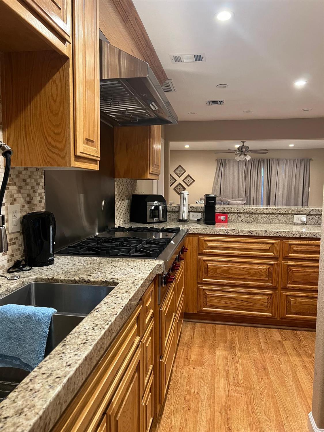 a kitchen with kitchen island granite countertop a sink and cabinets