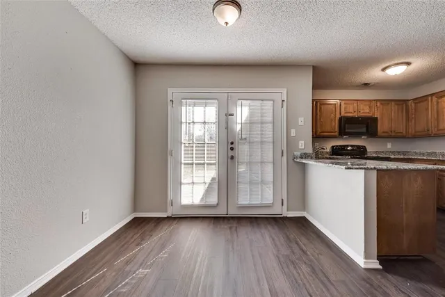 a kitchen with stainless steel appliances granite countertop a stove a sink and a microwave