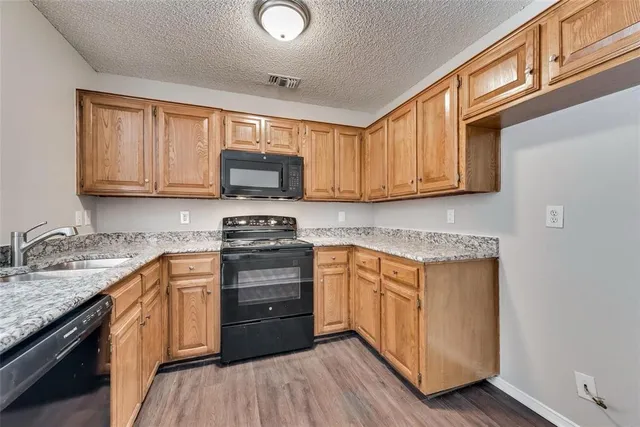 a kitchen with granite countertop wooden cabinets and white appliances