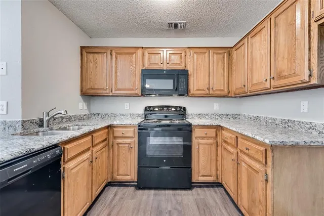 a kitchen with granite countertop a sink and cabinets