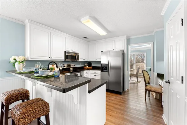 a kitchen with stainless steel appliances granite countertop a stove a sink and a microwave