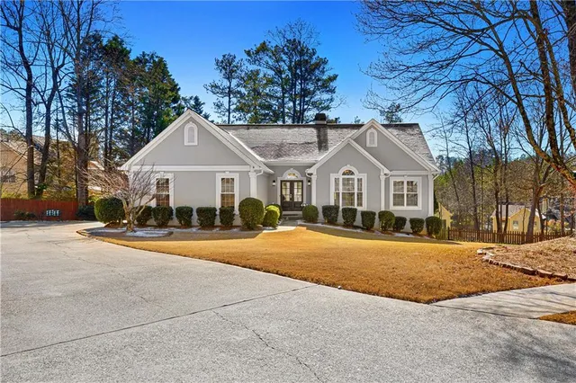 a front view of a house with a yard and trees