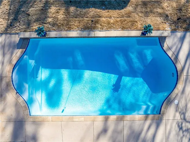a view of a house with pool and sitting area