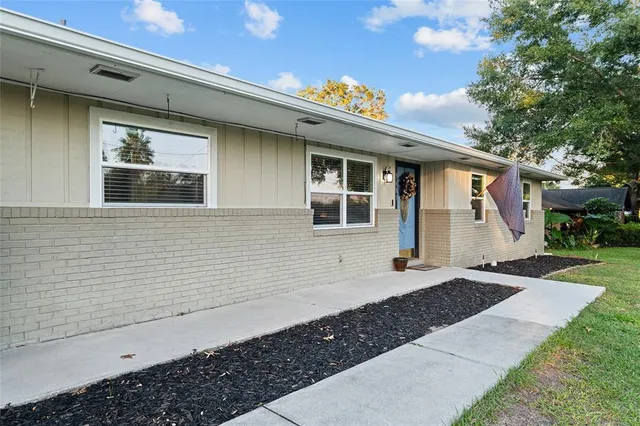 a living room with furniture a ceiling fan and a large window