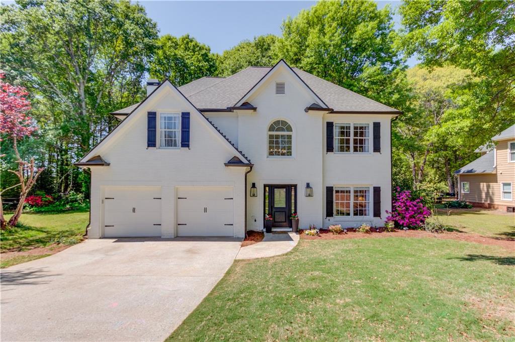 2310 Olde Hickory Place Monroe, GA 30656 - Photo 1 of 46 a view of a white house with a yard plants and a large tree