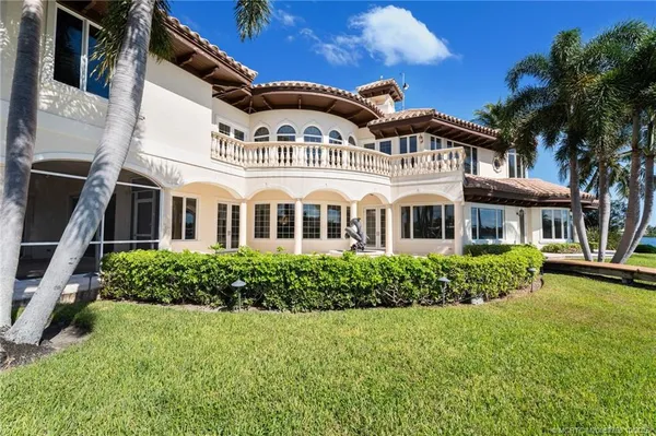 a view of a swimming pool with a lounge chair and palm trees
