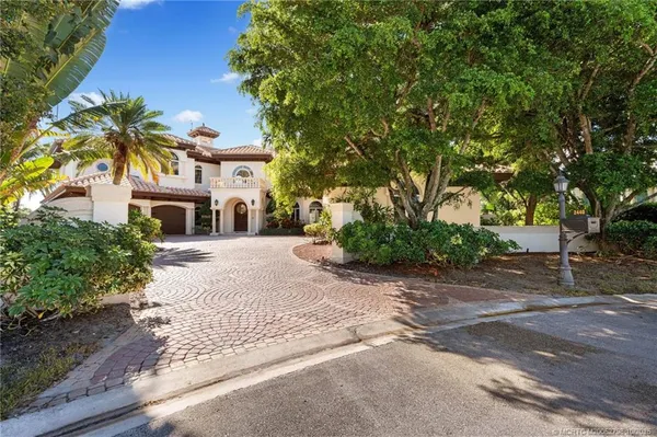 a front view of a house with a yard and trees