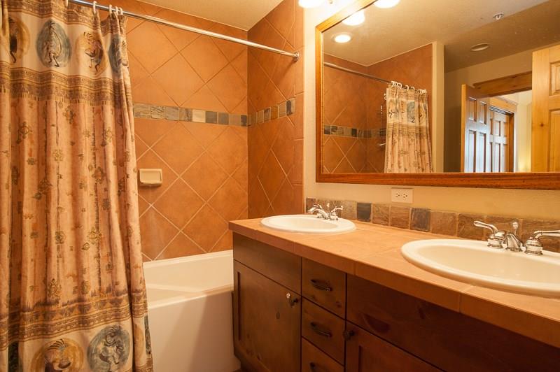 188 Tip Top Trail, Unit 6559 Keystone, CO 80435 - Photo 17 of 24 a bathroom with a granite countertop sink a mirror and a shower