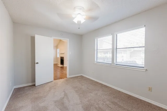 a view of empty room with window and ceiling fan