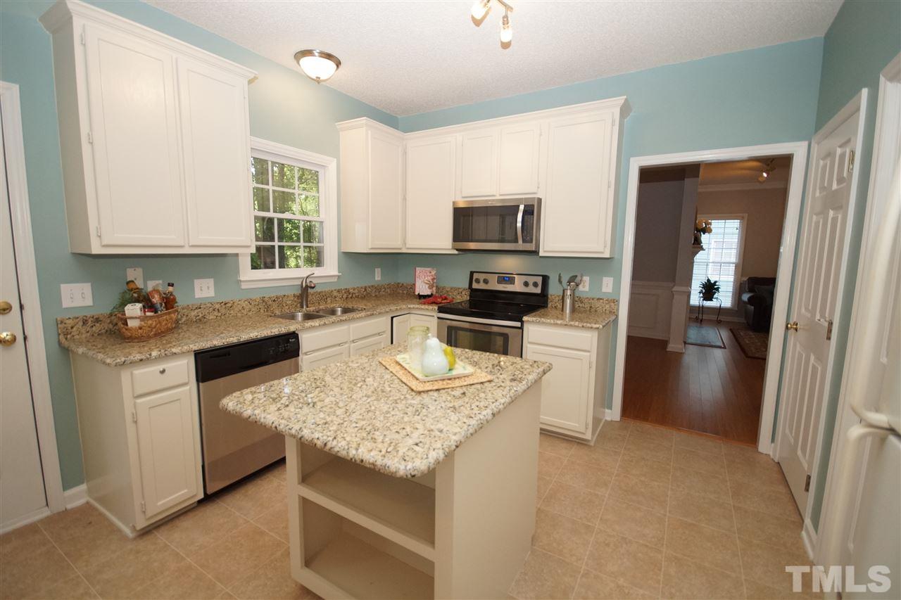 12317 Hartwick Court Raleigh, NC 27613 - Photo 10 of 24 a kitchen with kitchen island granite countertop a stove sink microwave and refrigerator