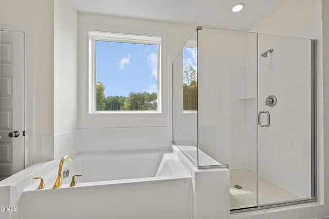 a white bath tub sitting next to a shower