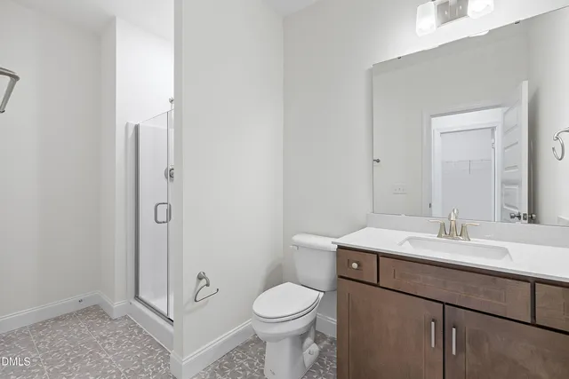 a bathroom with a toilet sink vanity and mirror