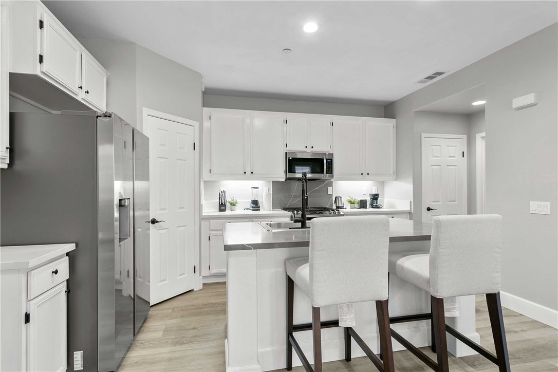 1746 Agrigento Avenue Riverside, CA 92507 - Photo 7 of 22 a kitchen with stainless steel appliances a refrigerator stove microwave and cabinets