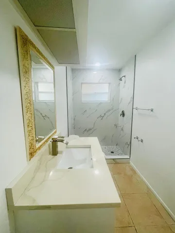 a white toilet sitting next to a bathroom sink and a mirror