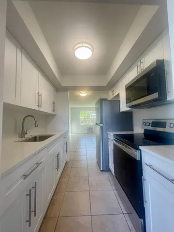 a kitchen with white cabinets and stainless steel appliances