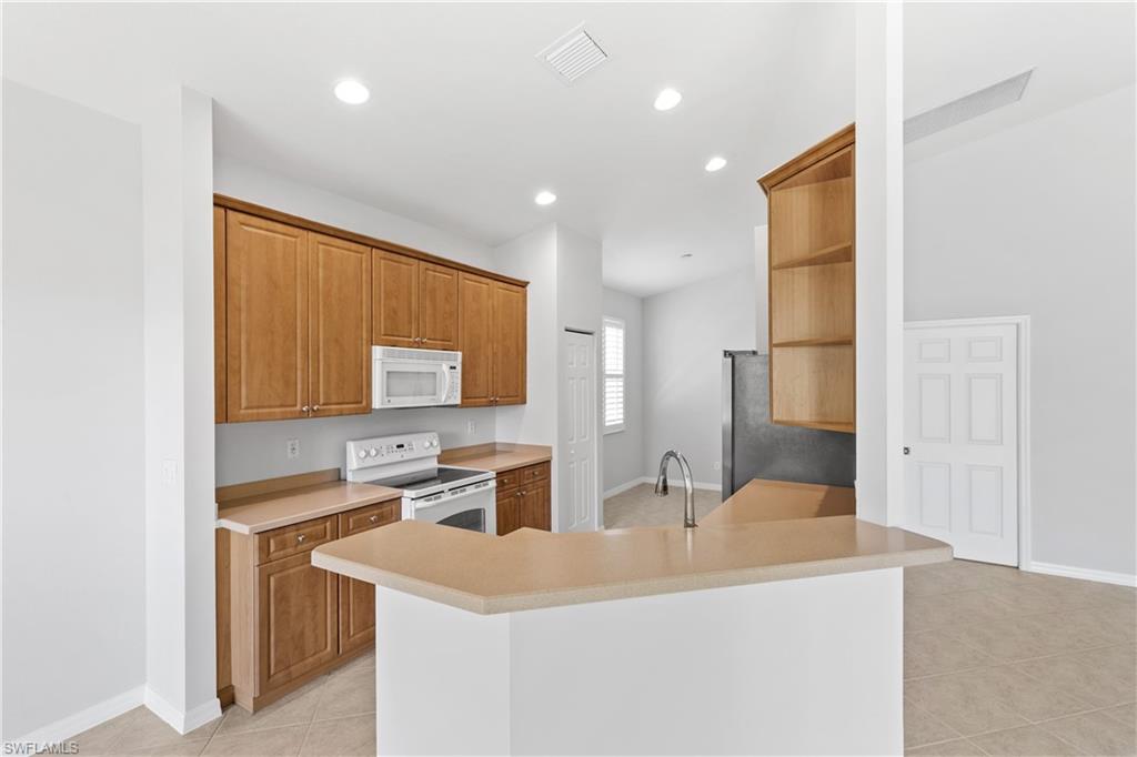 9300 Springview Loop Estero, FL 33928 - Photo 11 of 50 a kitchen with stainless steel appliances a sink and a refrigerator