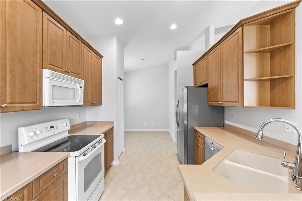 9300 Springview Loop Estero, FL 33928 - Photo 12 of 50 a kitchen that has a sink and a stove in it