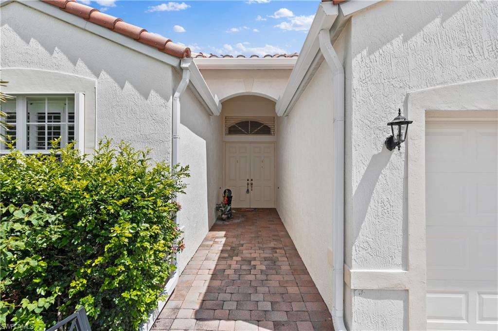 9300 Springview Loop Estero, FL 33928 - Photo 5 of 50 a view of a pathway of a house with potted plants