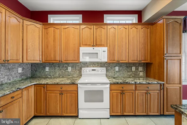 an empty room with ceiling fan and windows
