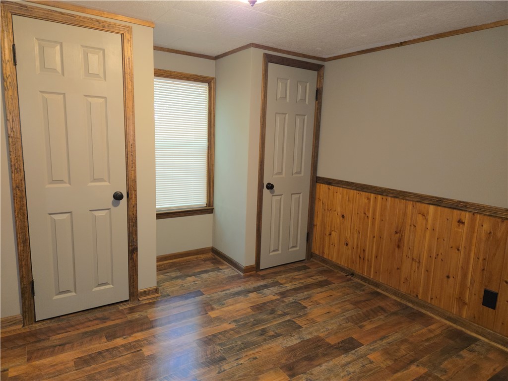 238 Forest Lane Starr, SC 29684 - Photo 8 of 11 Rich hardwood-style flooring and natural wood paneling create a cozy bedroom atmosphere.