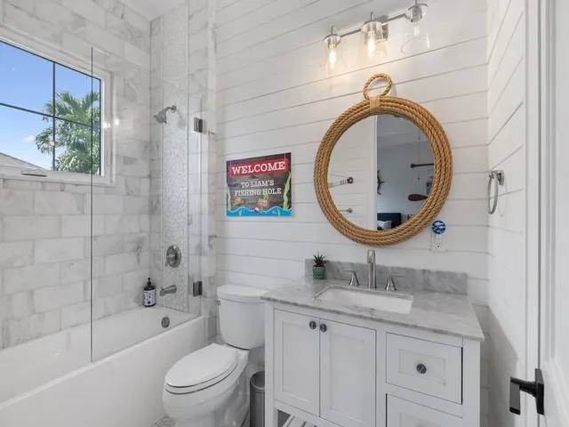 a bathroom with a granite countertop toilet a sink and a mirror