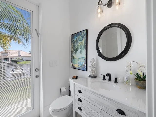 a bathroom with a toilet a sink and mirror