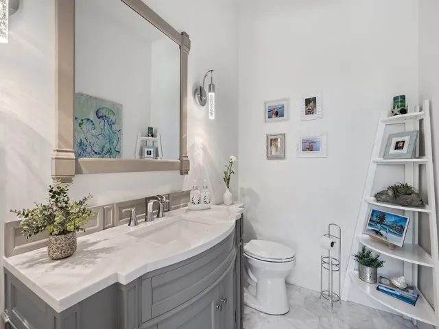 a bathroom with a granite countertop sink a toilet and a mirror