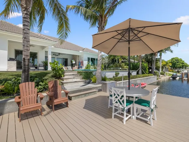 a view of a patio with a table and chairs under an umbrella with wooden floor