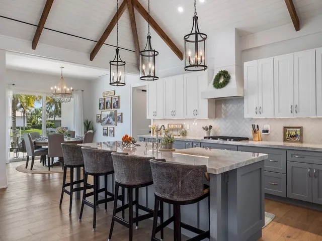 a kitchen with a dining table a sink stainless steel appliances and cabinets