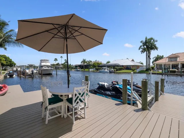 a view of a roof deck with table and chairs under an umbrella with wooden floor