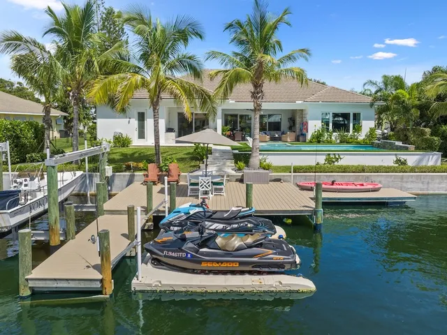 a view of a house with pool and chairs