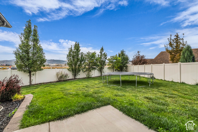 12992 West Geronimo Road Riverton, UT 84096 - Photo 21 of 25 Expansive backyard featuring a lush lawn, concrete patio, and a privacy fence