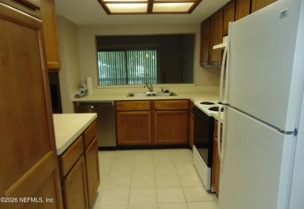 a kitchen with a sink a stove top oven and cabinets