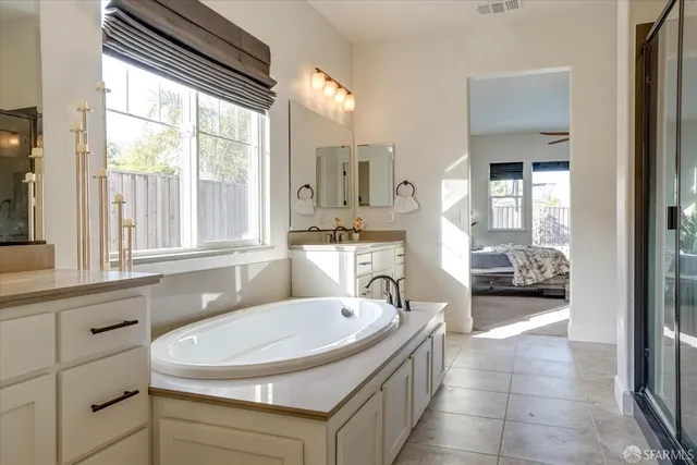 a en suite bathroom with a sink a mirror and next to a window