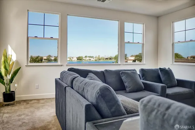 a living room with furniture a flat screen tv and a large window