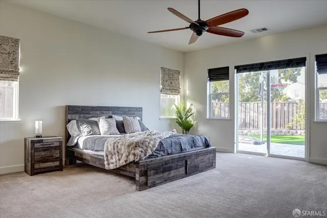 a bed sitting in a spacious bedroom next to a window