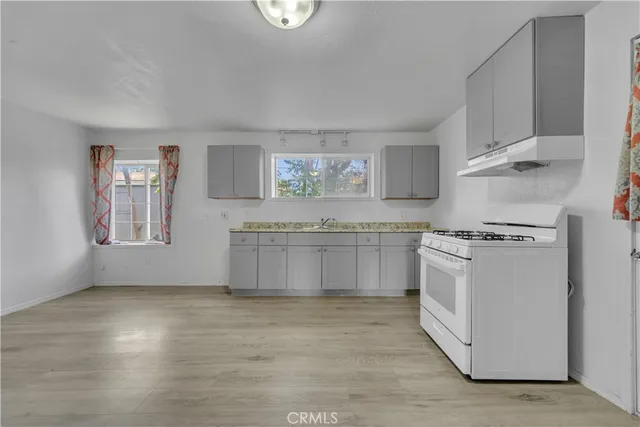 a kitchen with stainless steel appliances granite countertop a stove a sink and a refrigerator