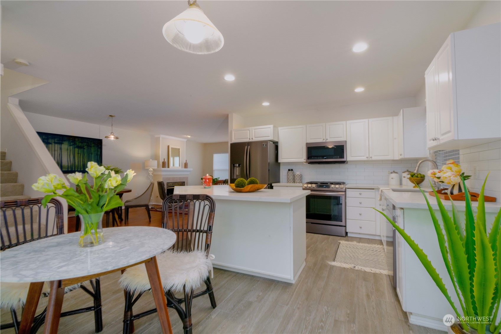 3725 Northeast 6th Street Renton, WA 98056 - Photo 6 of 19 a kitchen with stainless steel appliances a dining table chairs microwave and cabinets