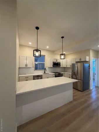 a kitchen with stainless steel appliances granite countertop a sink a refrigerator and a stove