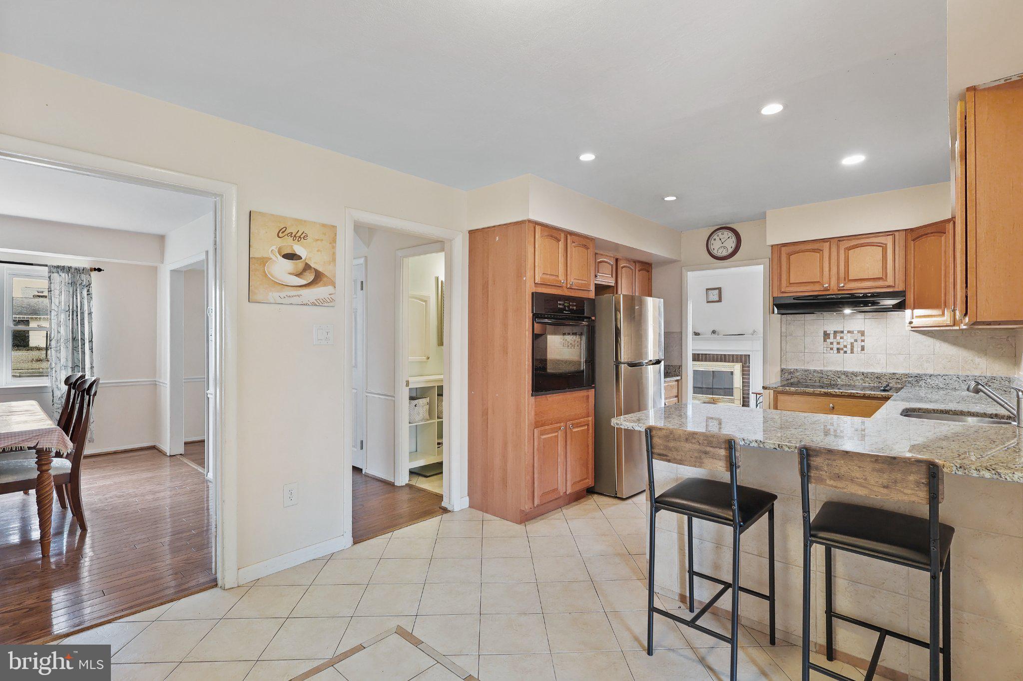 4228 Pageant Lane Fairfax, VA 22033 - Photo 11 of 33 a kitchen with stainless steel appliances kitchen island granite countertop a refrigerator and a stove top oven