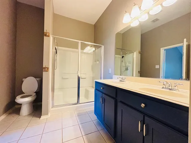 a bathroom with a double vanity sink mirror and toilet