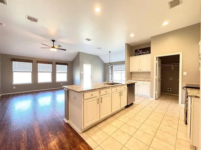 a large kitchen with a large counter top and stainless steel appliances