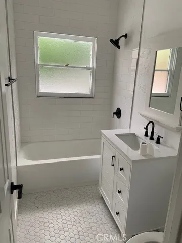 a bathroom with a tub sink and mirror