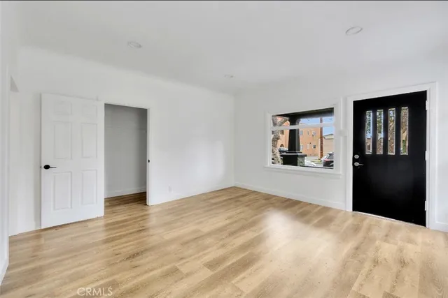 a view of a kitchen with wooden floor and a window