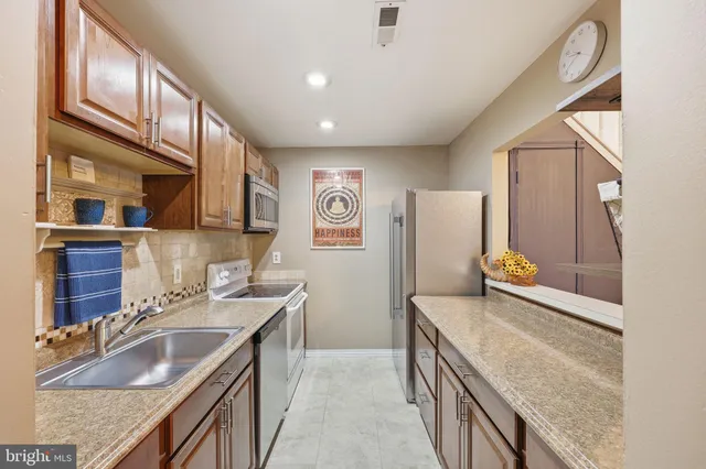 a bathroom with a granite countertop double vanity sink and mirror