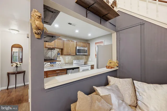 a large kitchen with stainless steel appliances kitchen island granite countertop a sink and cabinets