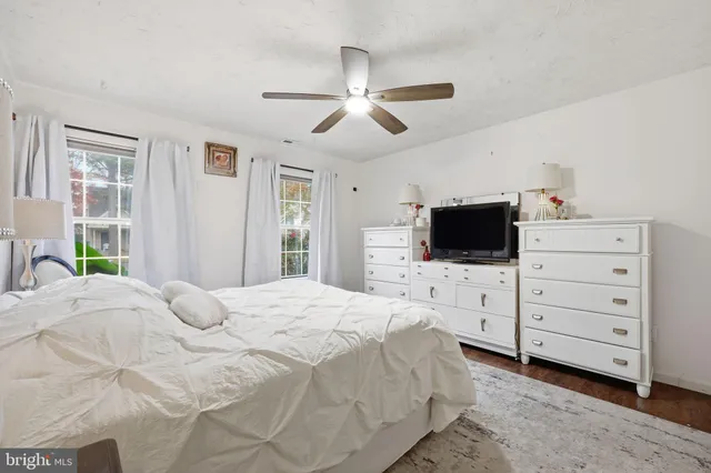 a bedroom with a bed a flat screen tv and a window