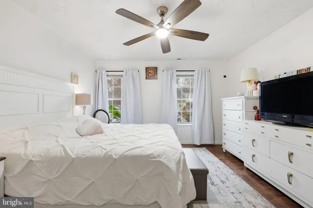 a bedroom with a bed and a flat screen tv on dresser