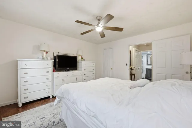 a bedroom with a bed and a ceiling fan