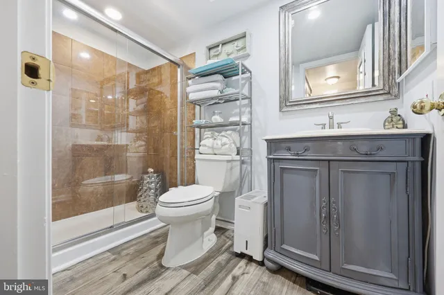 a bathroom with a granite countertop toilet a sink and a mirror